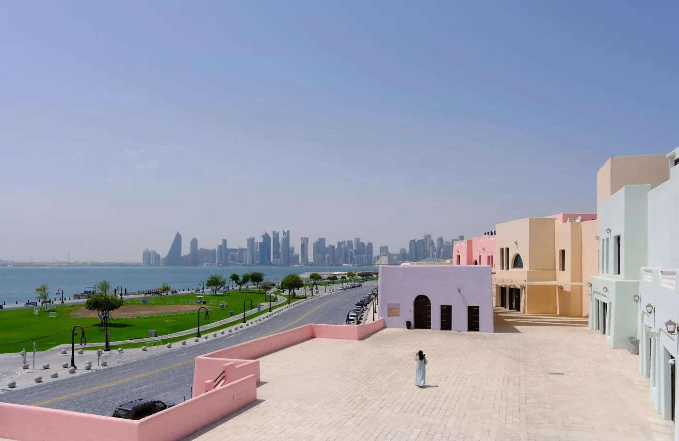 Pastel buildings in Mina District at Old Doha Port, with the West Bay skyline across the bay